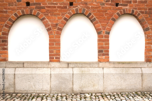 three windows on the red brick wall