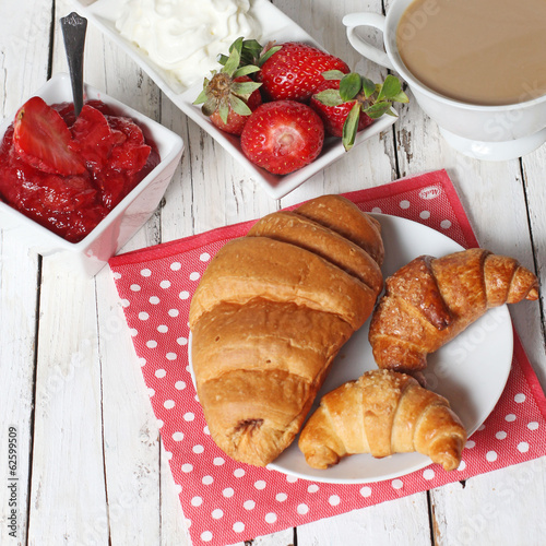 breakfast with croissants  strawberry  and cup of coffe on white