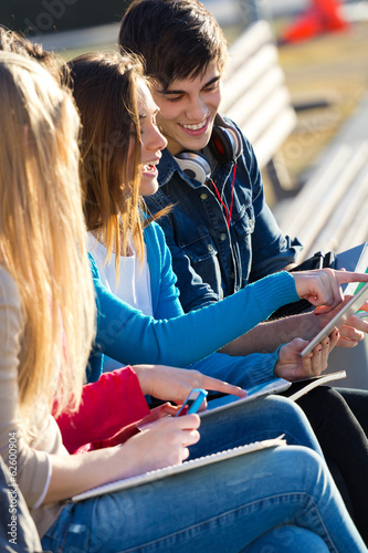 Students having fun with digital devices after class photo