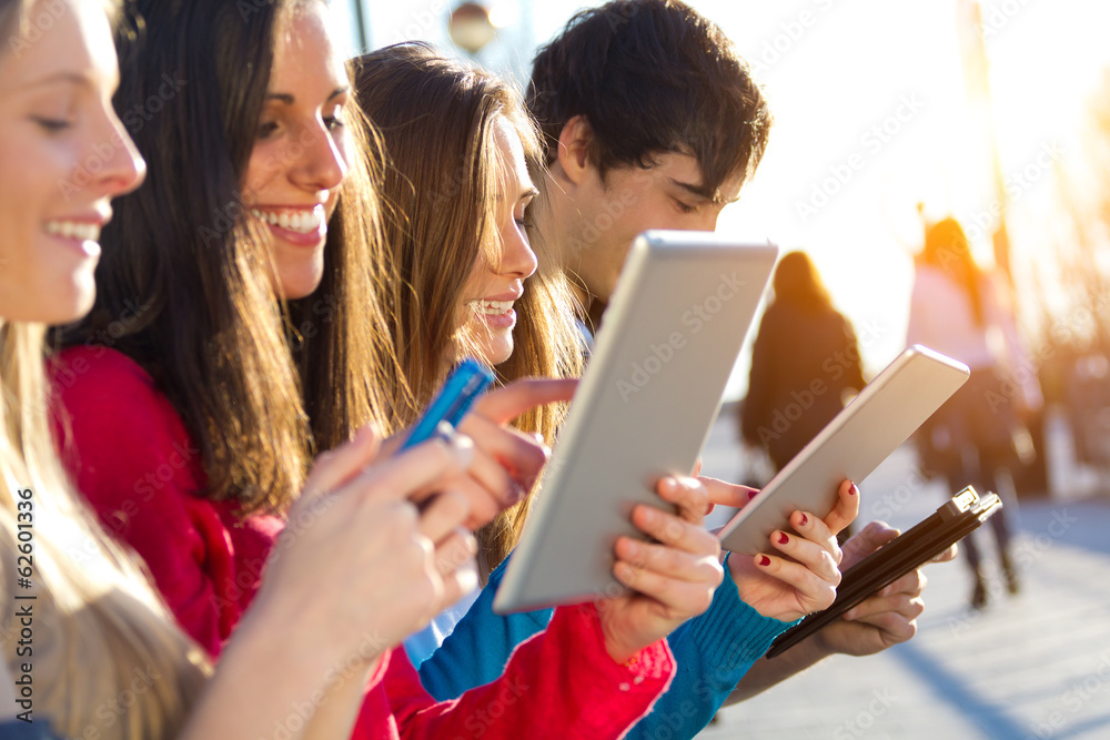 Obraz premium Students having fun with digital devices after class