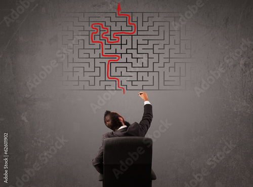 Business man looking at a maze and the way out