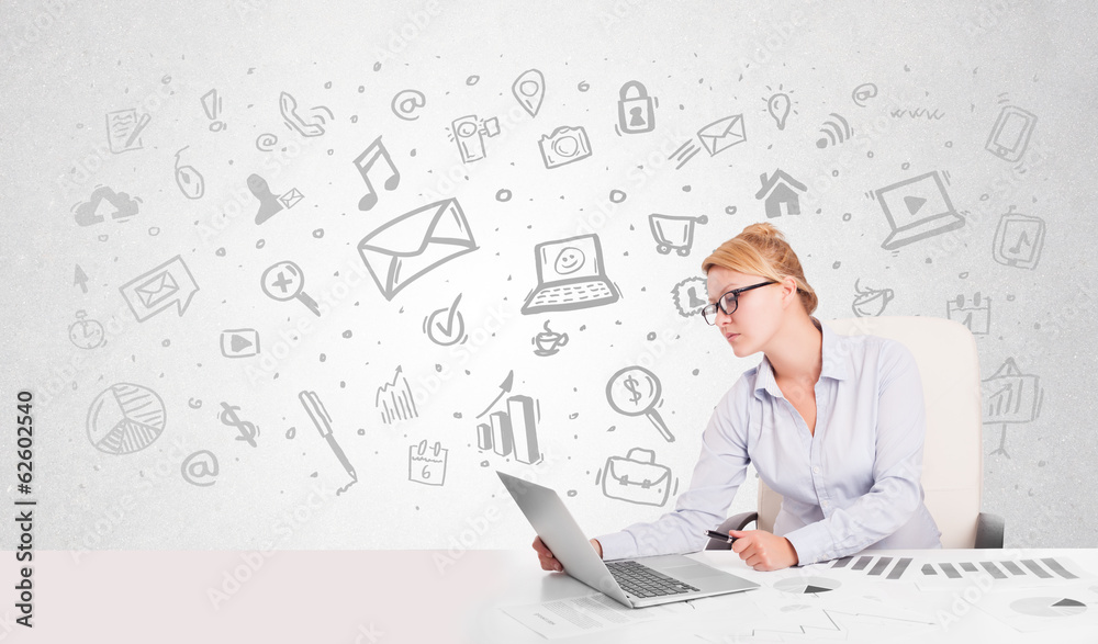 Business woman sitting at table with hand drawn media icons Business woman sitting at table with hand drawn media icons