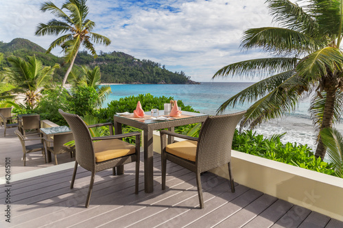 Table with chairs on decking, by the sea