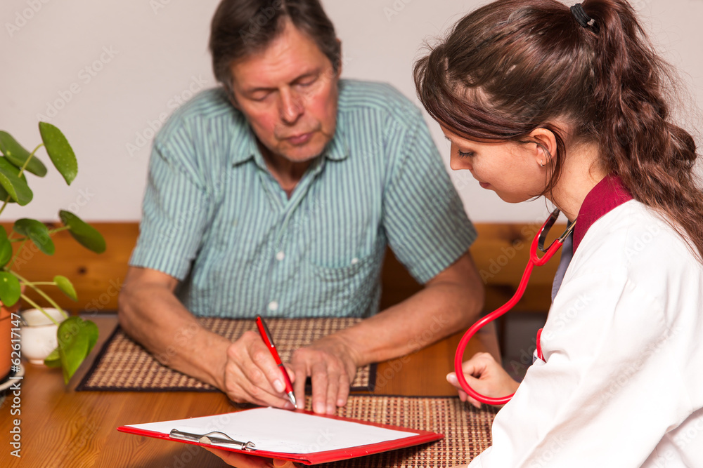 Senior unterschreibt Dokumentation von Altenpflegerin Senior unterschreibt Dokumentation von Altenpflegerin