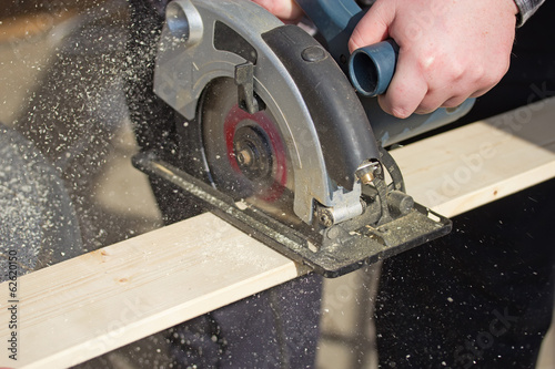 Man is working with electric circular saw