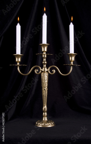 Vintage brass candelabrum with three burning candles photo