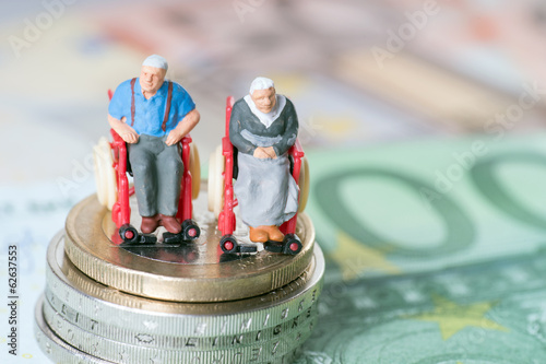 Altes Ehepaar im Rollstuhl mit Geld photo