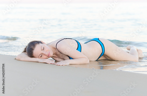 Woman lying on the beach sand.