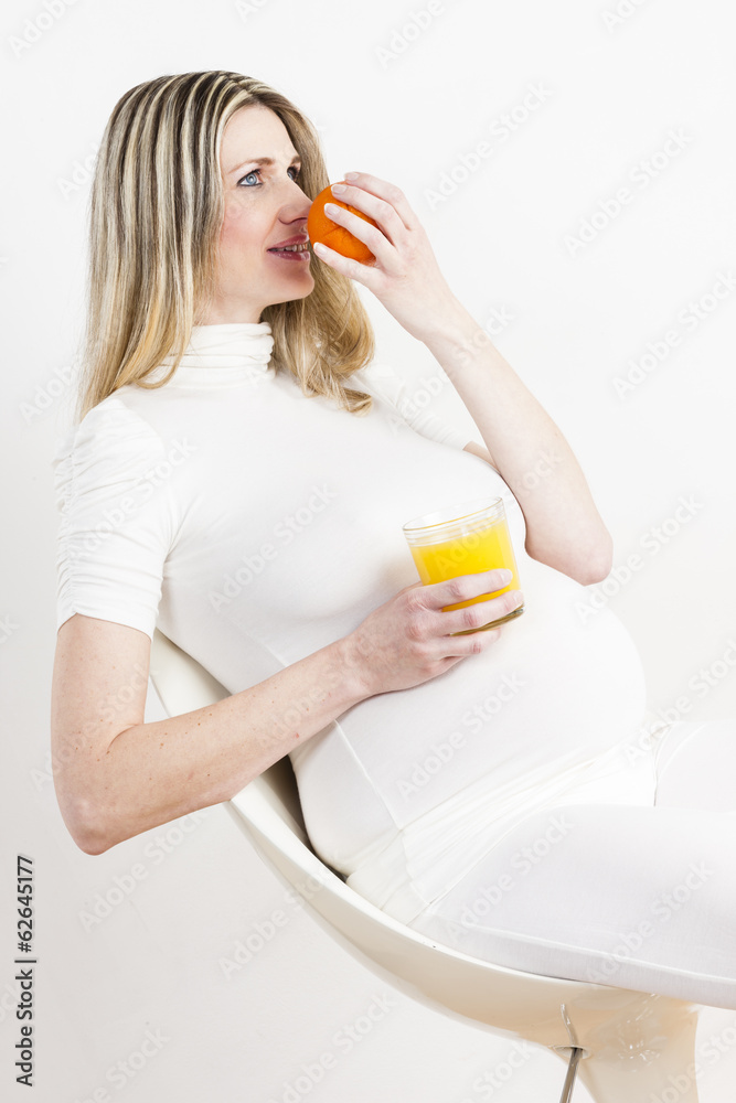 portrait of pregnant woman with a glass of orange juice and an o portrait of pregnant woman with a glass of orange juice and an o