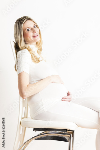 portrait of sitting pregnant woman wearing white clothes