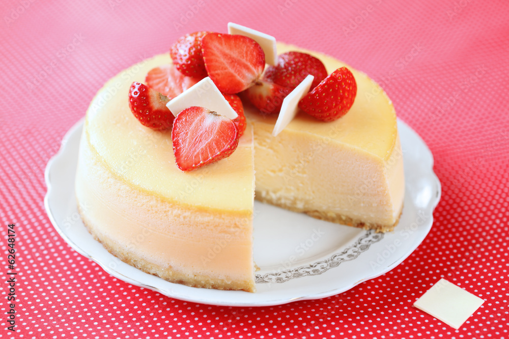 Vanilla Strawberry Cheesecake on a red background. Vanilla Strawberry Cheesecake on a red background.