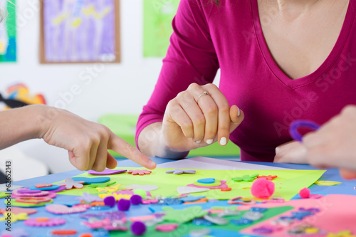 Teacher playing colourful puzzles with kids