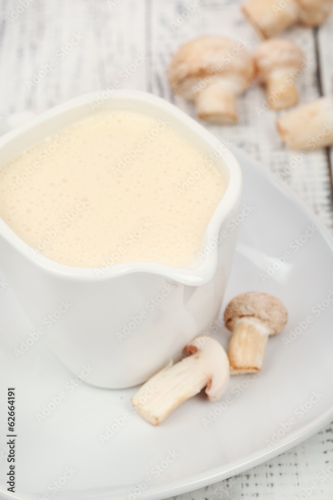 Delicate mushroom sauce in pitcher on wooden table close-up Delicate mushroom sauce in pitcher on wooden table close-up