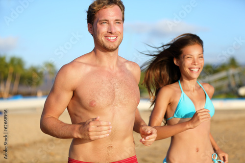 Running athletic couple jogging on beach