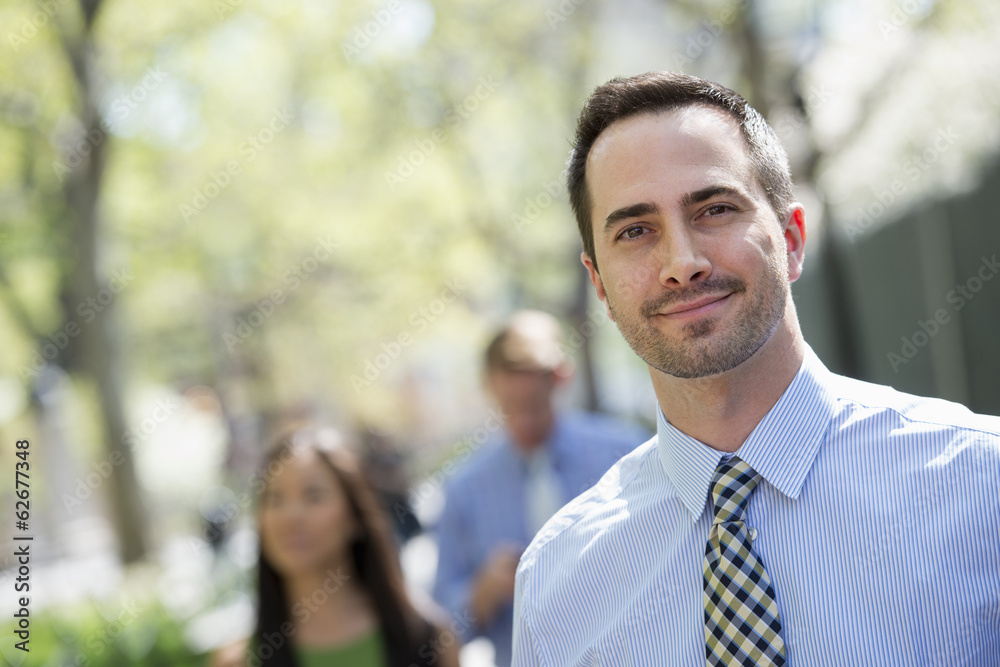 A Small Group Of People, A Businesswoman And Two Businessmen Outdoors In The City.