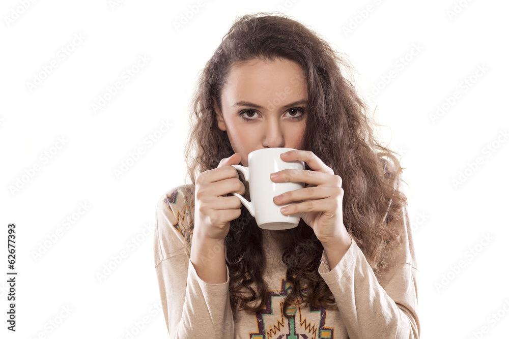 young girl drinking from a mug on white background