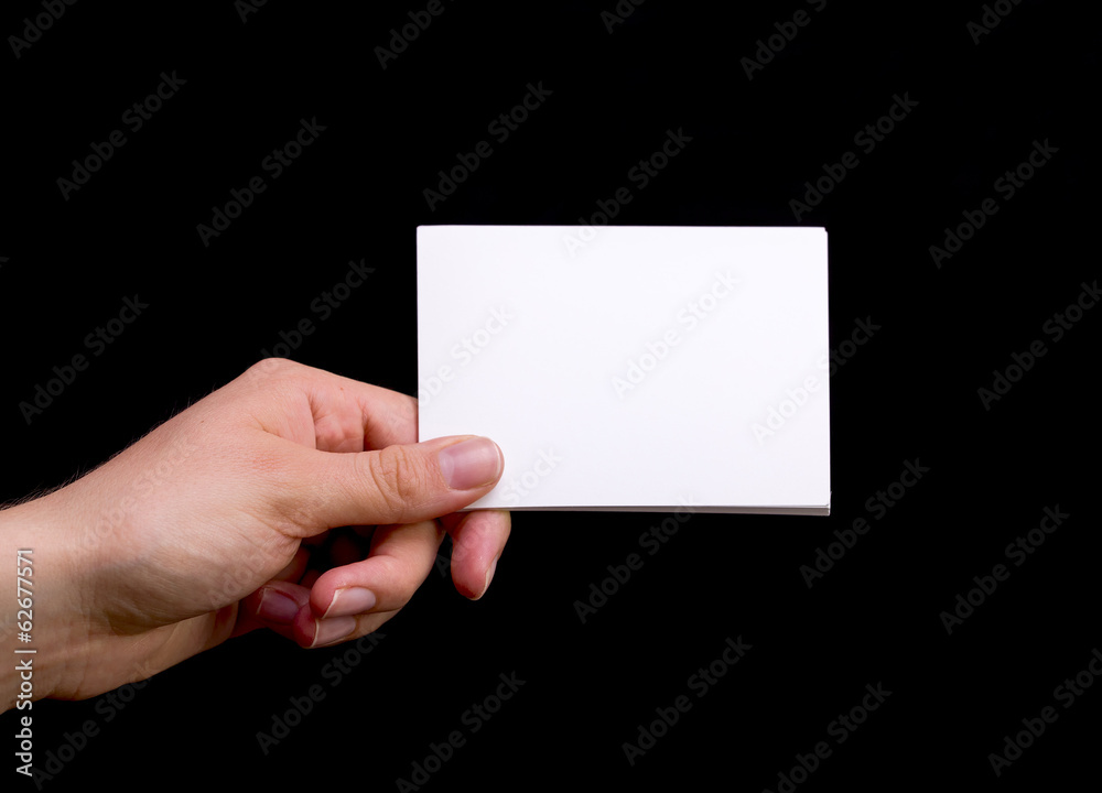 Female Hand Holding White Blank Card on Black Background Female Hand Holding White Blank Card on Black Background