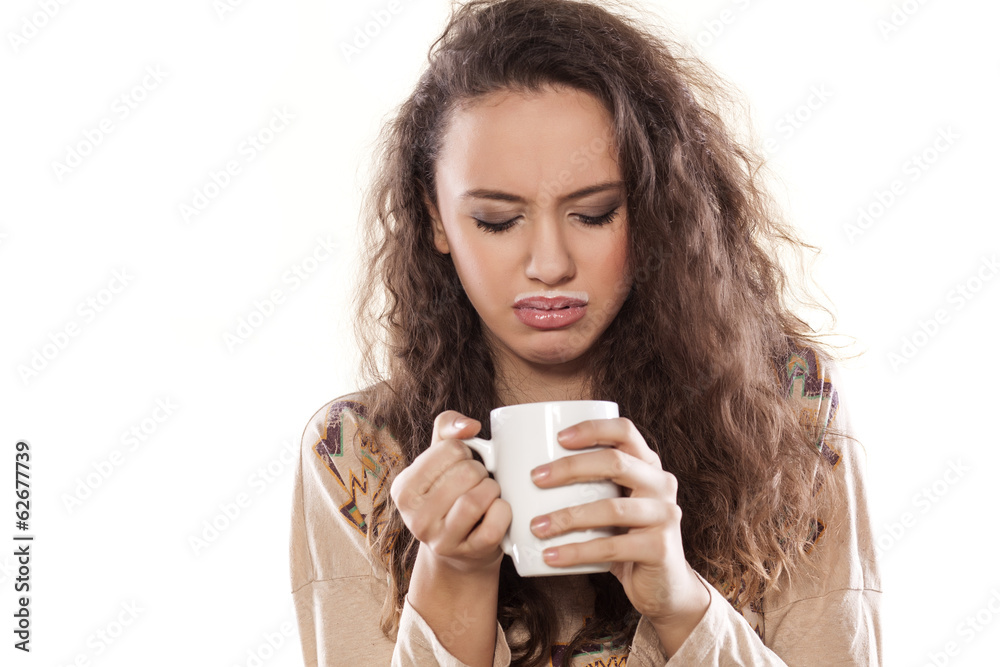disgusted young girl looking into a cup with milk disgusted young girl looking into a cup with milk