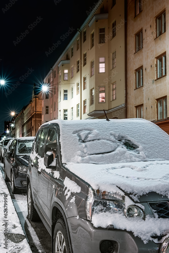Car covered with snow on winter night