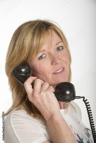 Portrait of a woman using an old style black telephone