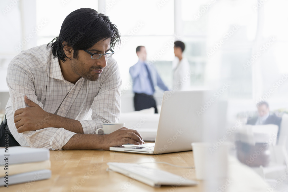Office. A Young Man Using A Laptop Computer On A Desk. Office. A Young Man Using A Laptop Computer On A Desk.