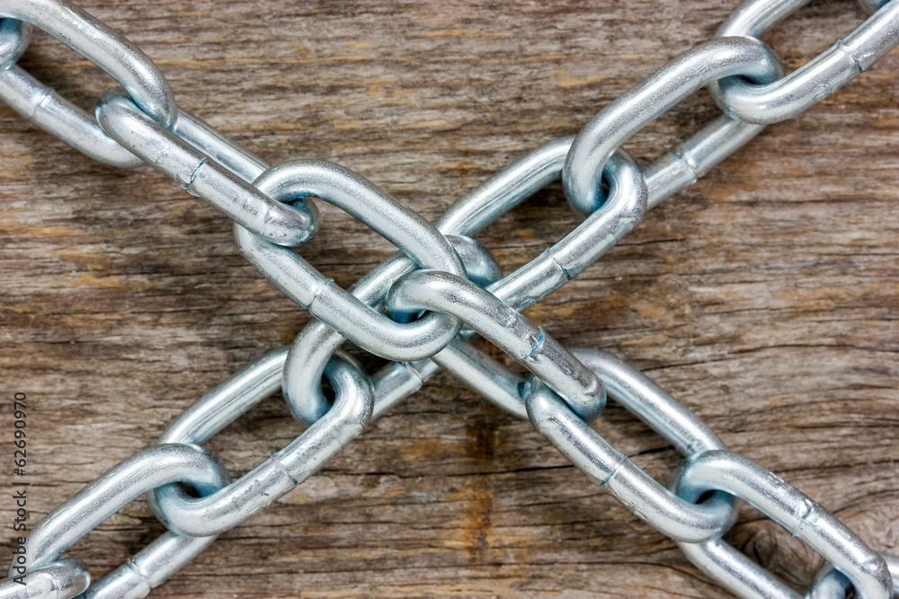 Chains crossed on the wooden background Chains crossed on the wooden background