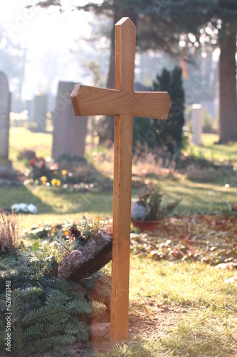 Holzkreuz auf Friedhof in Morgensonne
