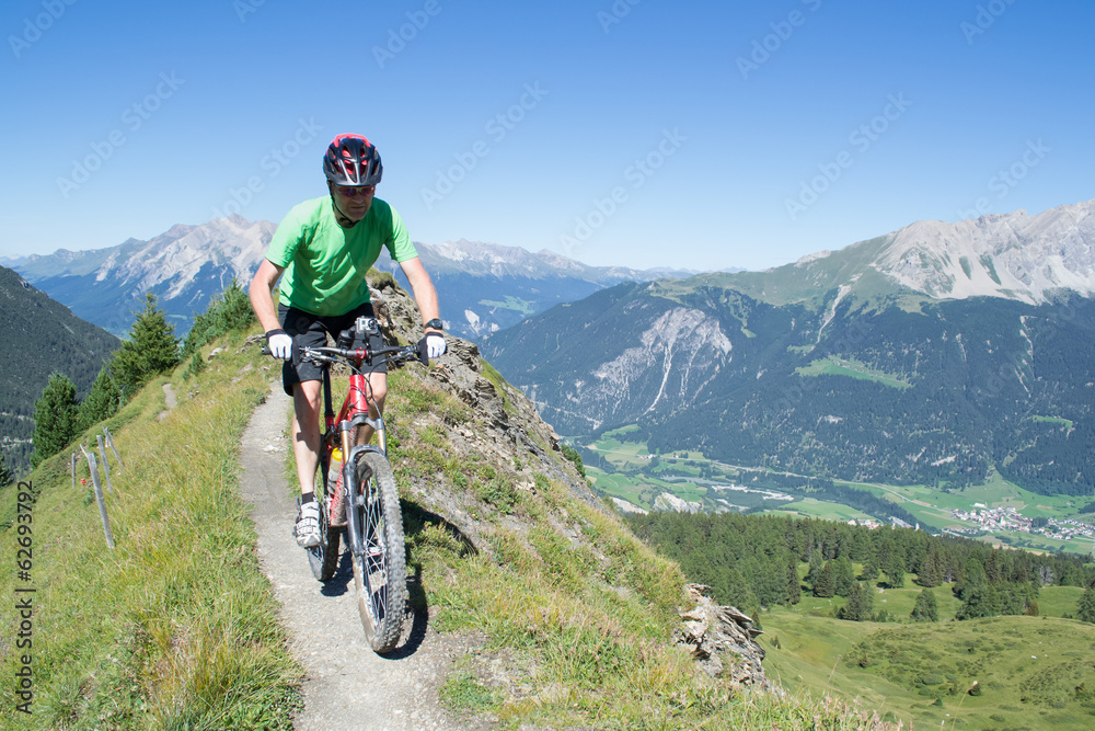 Mountain biker riding downhill in Swiss Alps