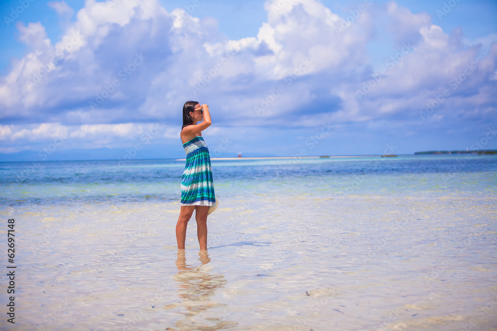 Young woman enjoying the holiday on a white, tropical beach at