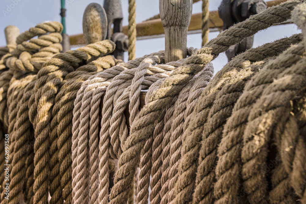 Ropes and wooden pulley in an old yacht, sunset