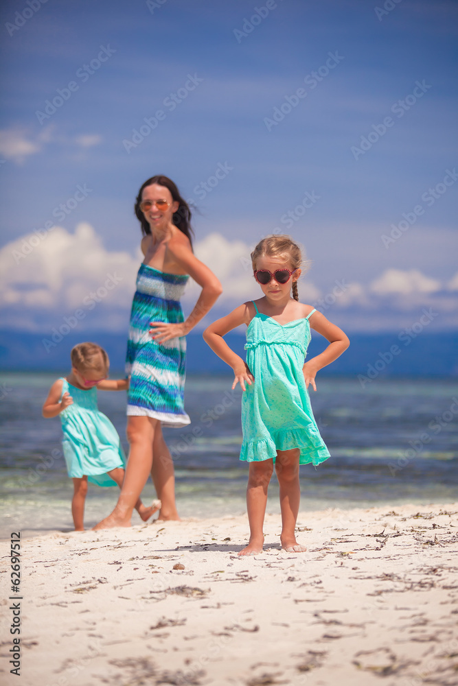 Young mother and two her daughters have fun at exotic beach on