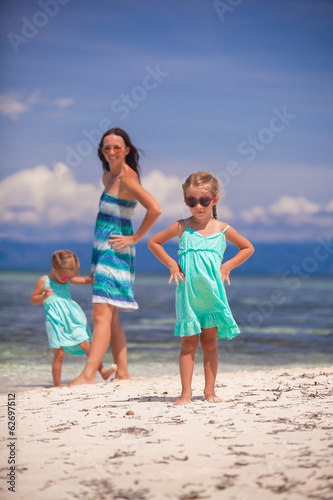 Young mother and two her daughters have fun at exotic beach on