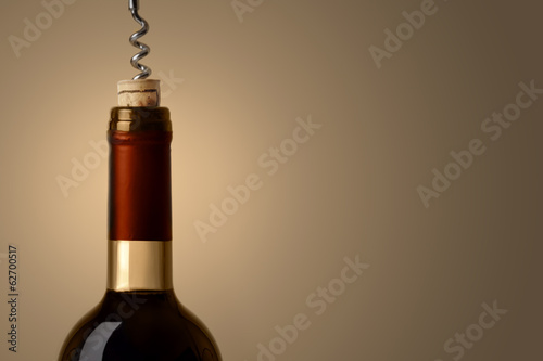 Opening a bottle of wine, on red background
