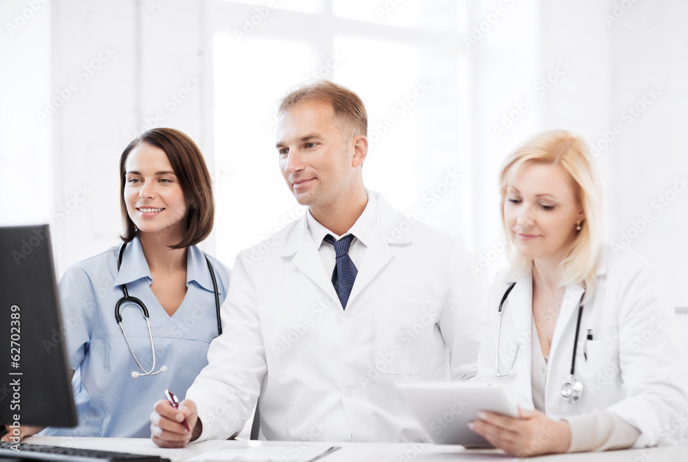 doctors looking at computer on meeting doctors looking at computer on meeting