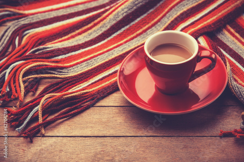 Red cup of the coffee and vintage scarf. photo