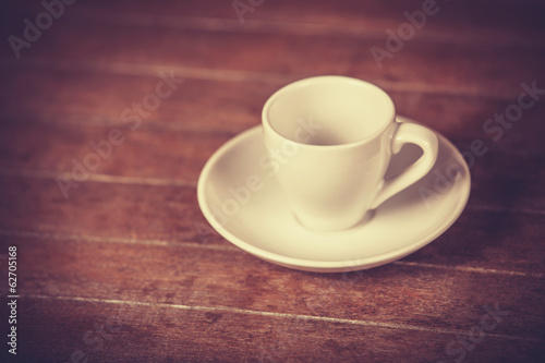 Little and empty cup for a coffeeor tea on a wooden table