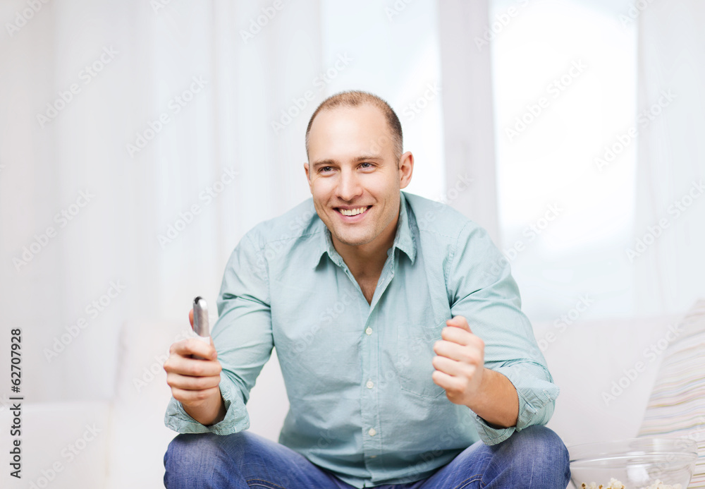 Fototapeta premium smiling man watching sports at home
