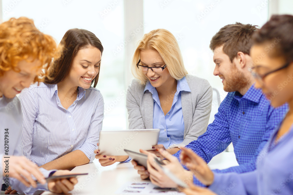 smiling team with table pc and papers working smiling team with table pc and papers working