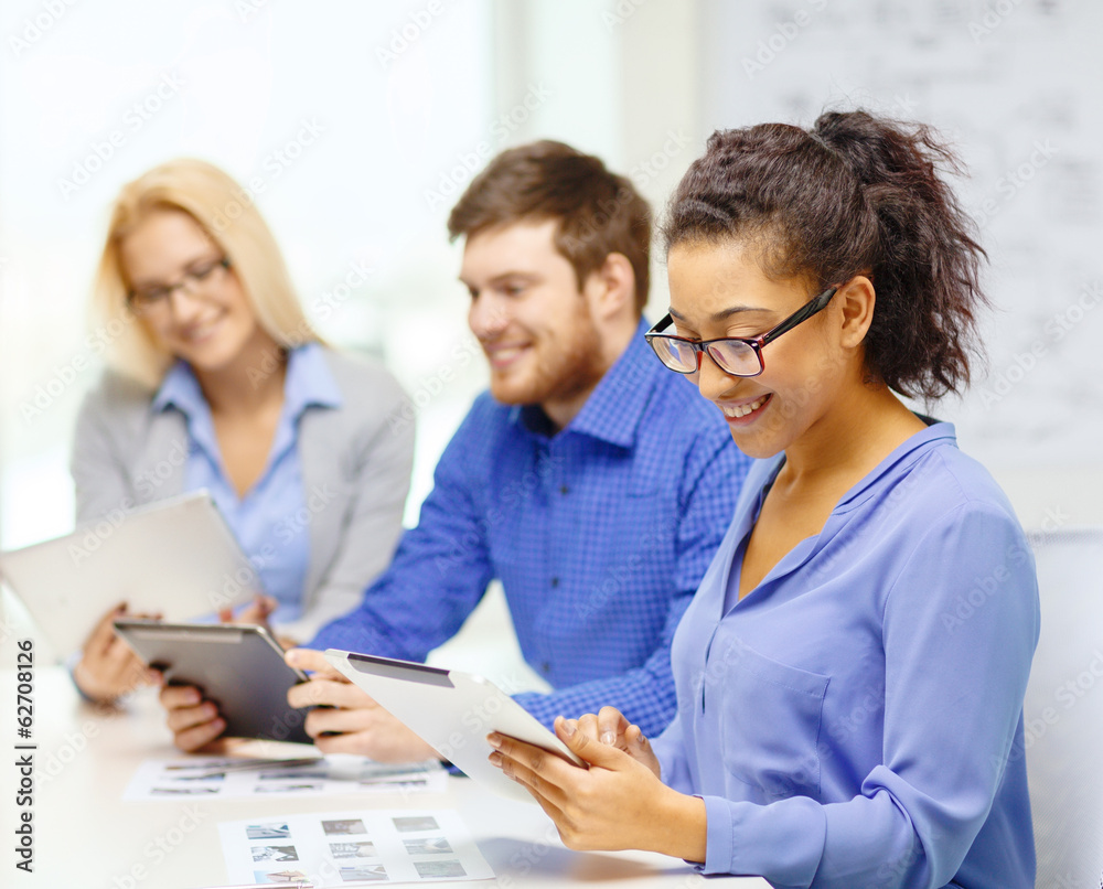 smiling team with table pc and papers working smiling team with table pc and papers working