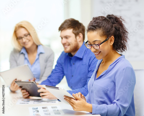 smiling team with table pc and papers working