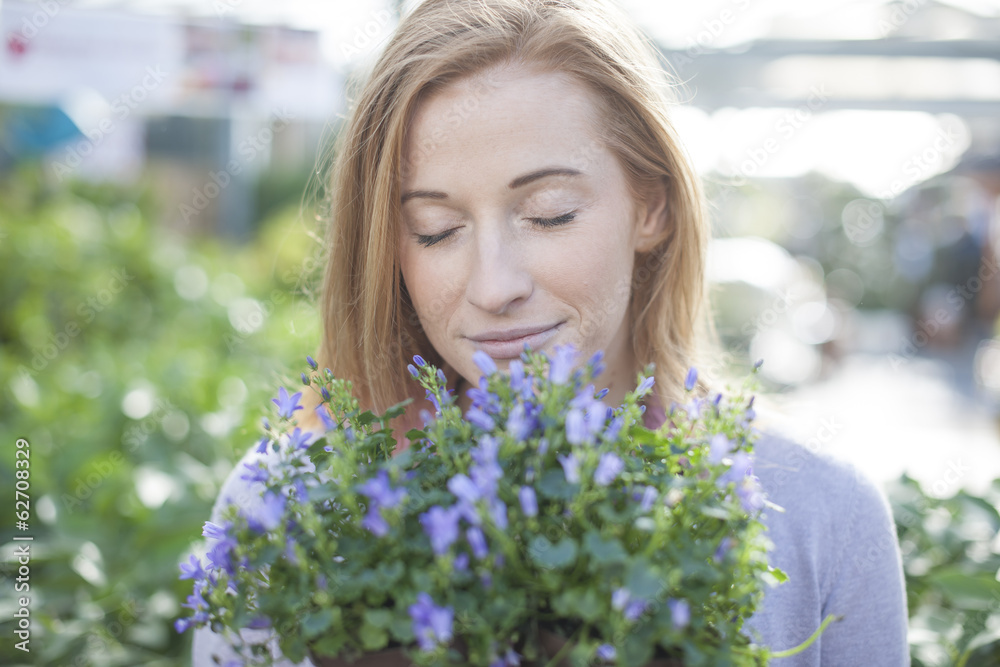 young woman choosing some flowers to plant in her garden young woman choosing some flowers to plant in her garden