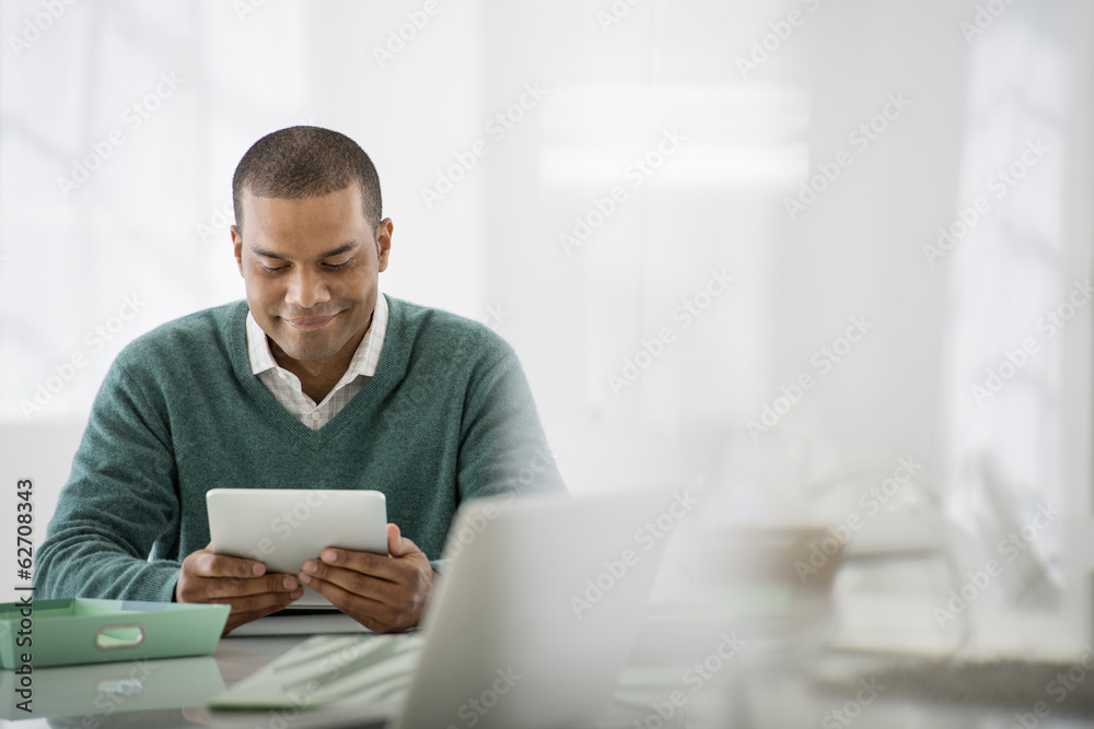 Business. A Light Airy Office Environment. A Man Sitting Holding A Digital Tablet. Business. A Light Airy Office Environment. A Man Sitting Holding A Digital Tablet.