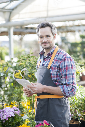 Professional gardener using a digital tablet in a garden center photo