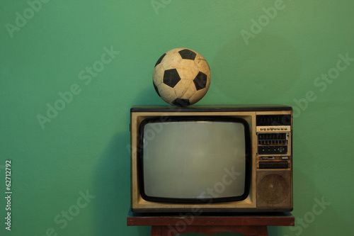An old soccer ball on a retro TV with retro green paint wall