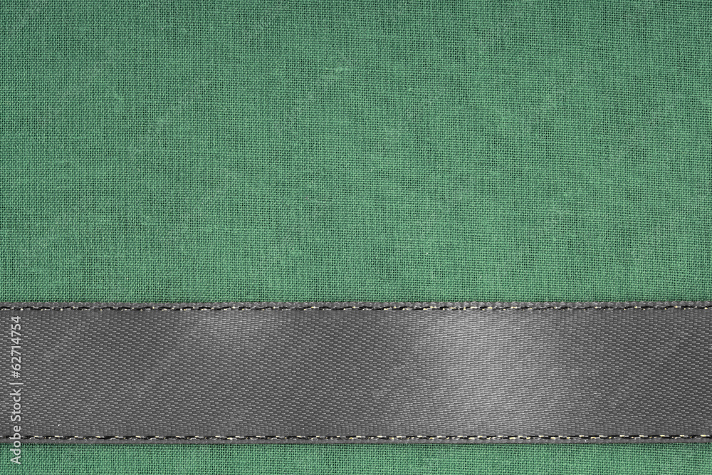 Fototapeta premium Gray ribbon on green fabric background with copy space.