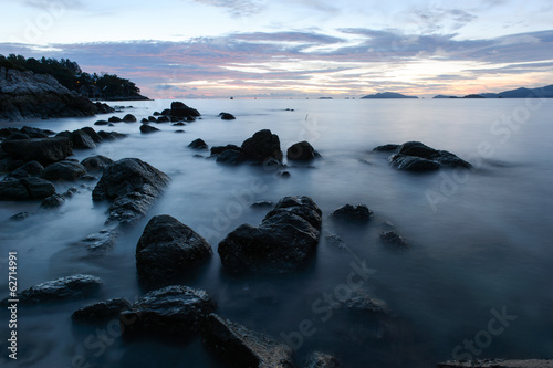 beach with rocks and waves; sunset background