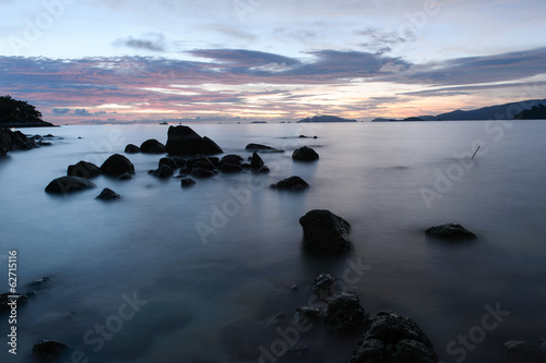 beach with rocks and waves; sunset background