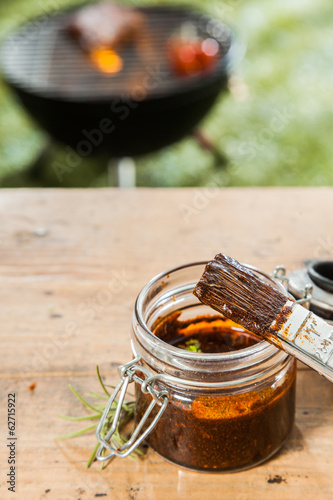 Bilde på lerret Jar of basting sauce for the meat on the BBQ