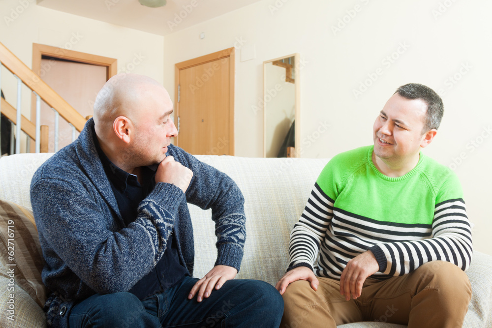 Fototapeta premium men sitting on sofa at home and talking