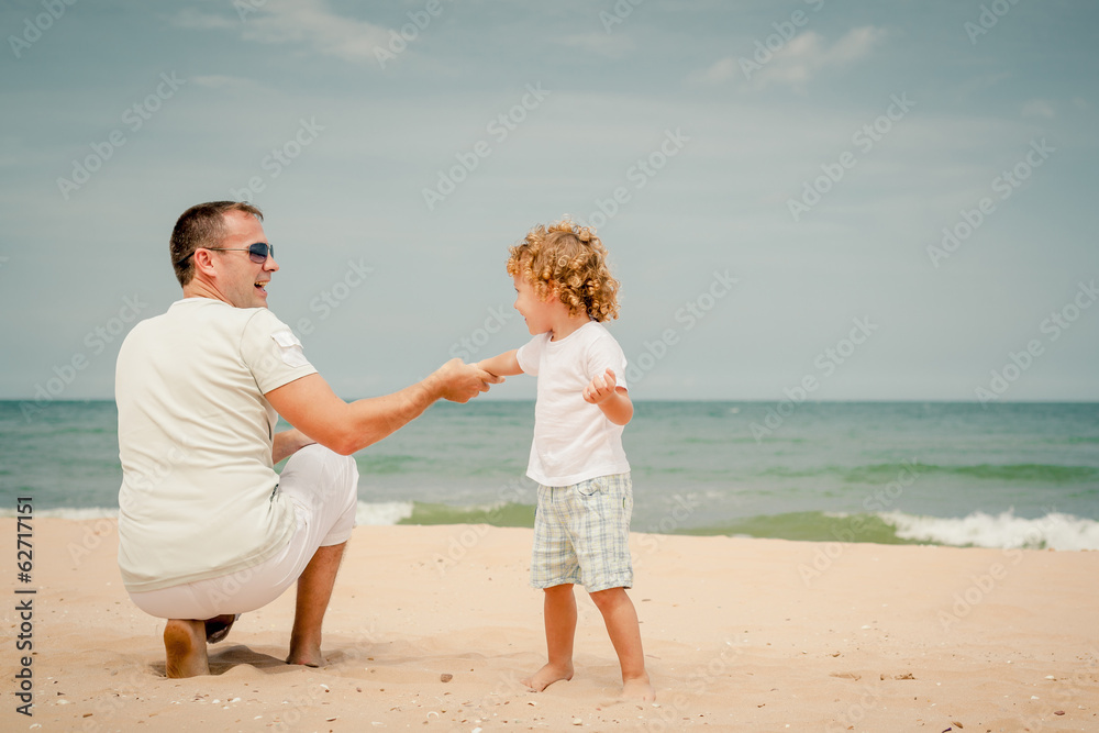 father and son playing at the beach in the day time